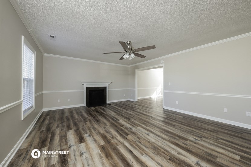 the living room of a manufactured home with wood flooring and a ceiling fan