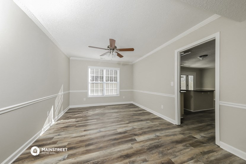 the living room of an empty house with a ceiling fan