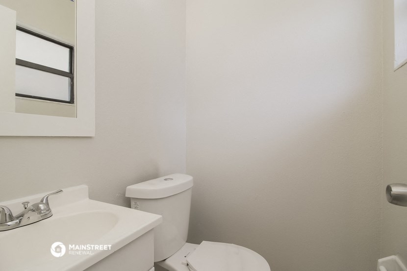 a white bathroom with a toilet and a sink