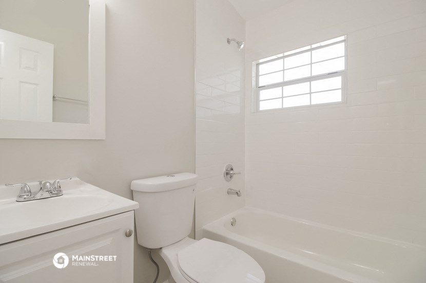 a bathroom with a toilet and a tub and a sink