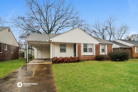 a small white house on a rainy day in a grass yard