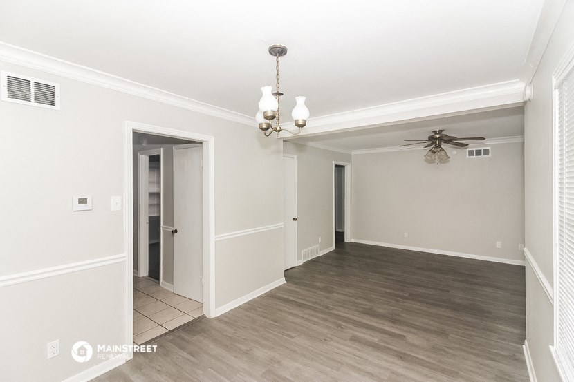 an empty living room with white walls and a ceiling fan