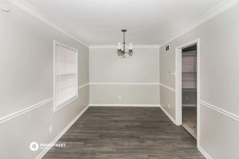 an empty living room with wood flooring and white walls