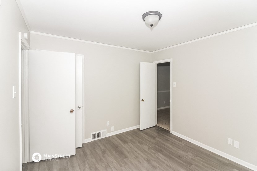 an empty room with white walls and a door to a closet