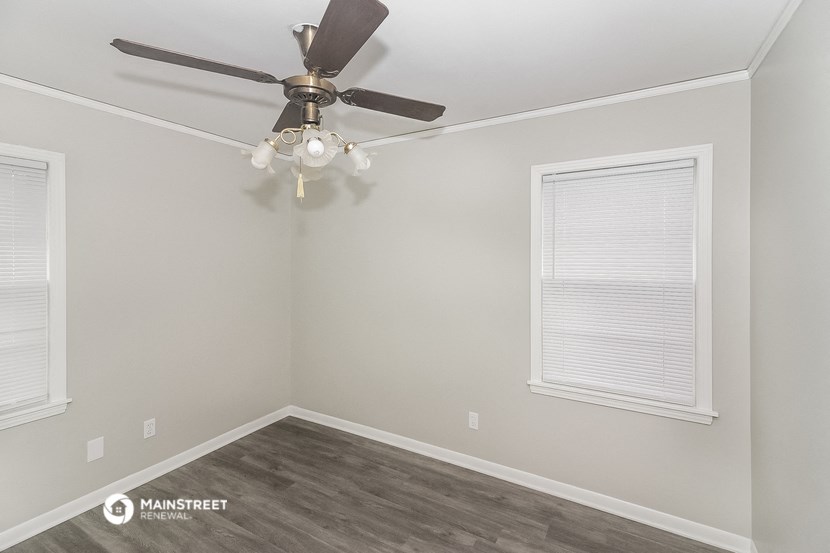an empty room with a ceiling fan and a window