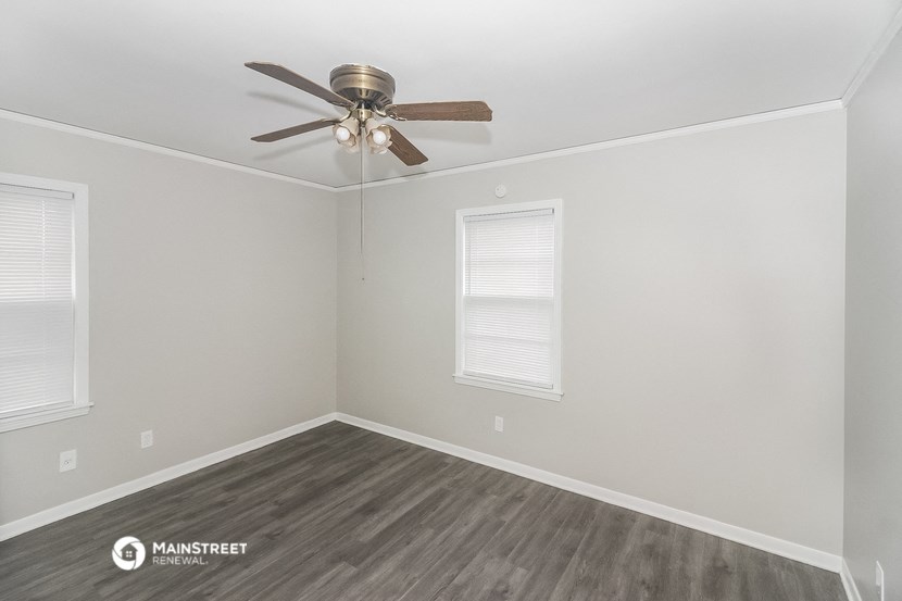 the living room of an empty house with a ceiling fan