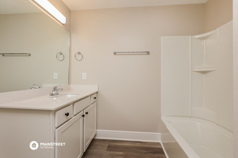 a bathroom with a sink and a shower and a tub