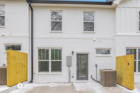 the front of a white building with a boarded up door