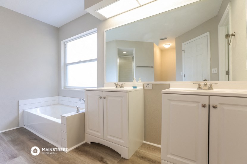 a bathroom with a tub and a sink and a mirror