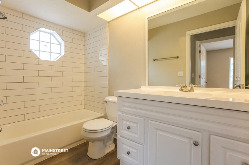 a bathroom with a toilet and a sink and a mirror