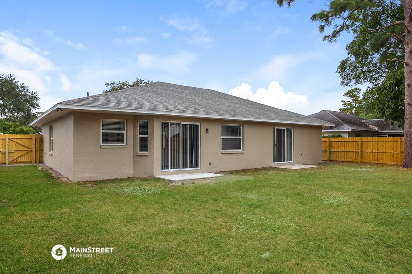 a brown house with a yard and a wooden fence