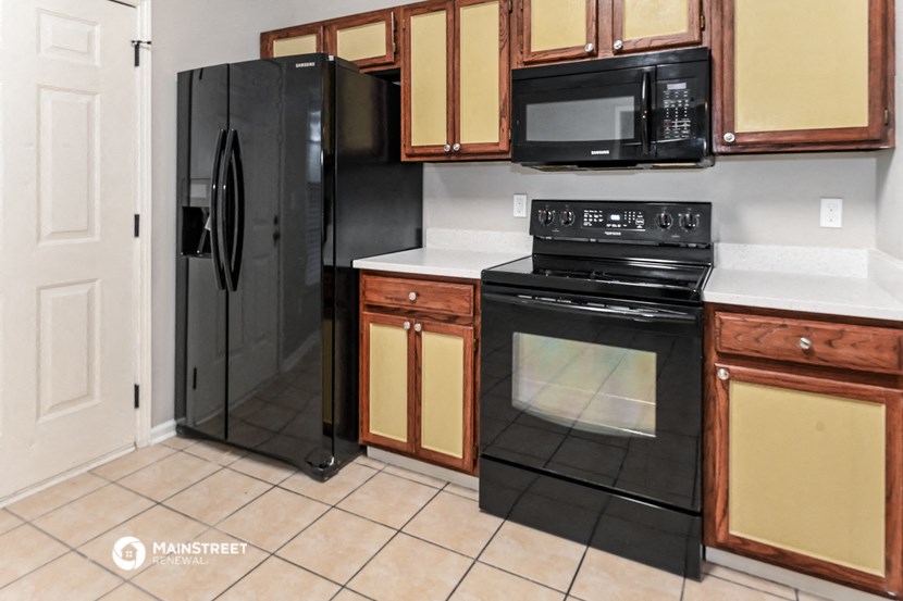 a kitchen with black appliances and wooden cabinets