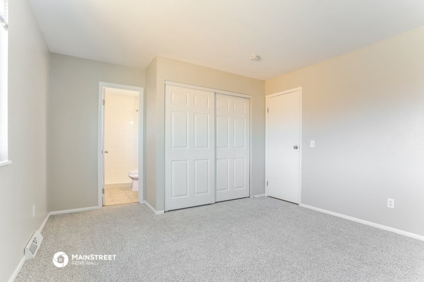 a bedroom with two closets and a door to the bathroom