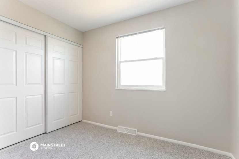 a bedroom with two closets and a window