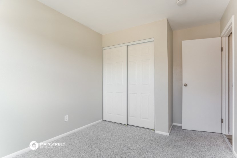 a bedroom with two closets and a door to a closet