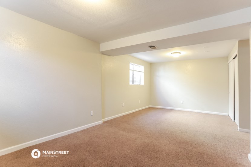 the spacious living room with carpeting and a window