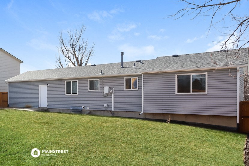 a gray house with a yard in front of it