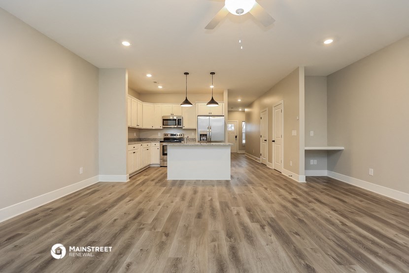 an open kitchen and living room with wood flooring