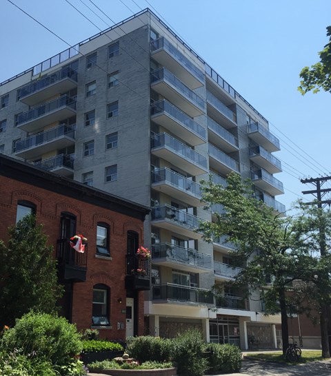 a tall apartment building with a brick building next to it