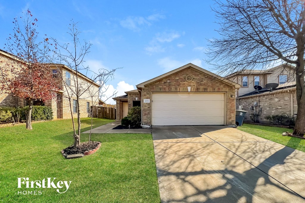 a house with a garage door and a lawn