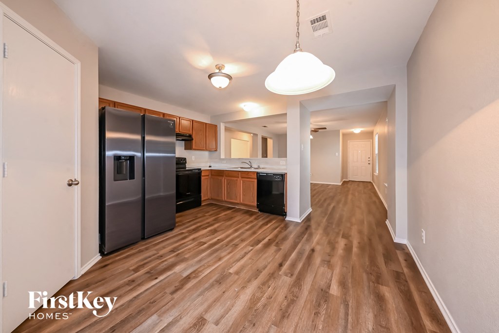 a spacious kitchen with stainless steel appliances and wood flooring