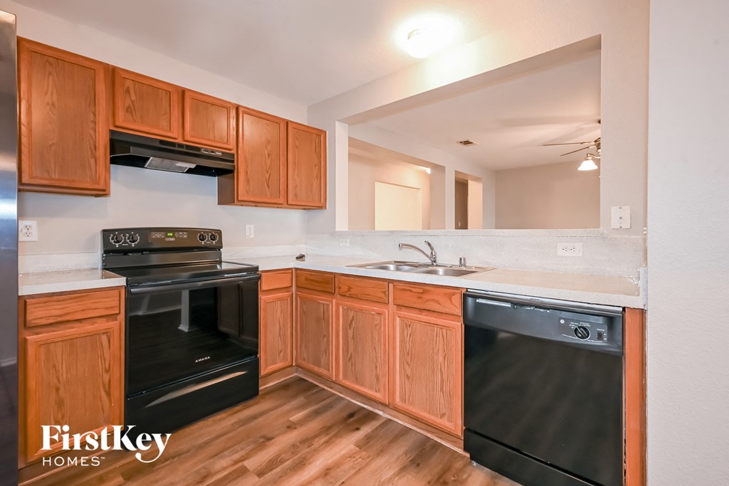 a kitchen with black appliances and wooden cabinets