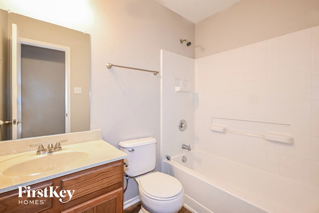 a bathroom with a toilet and a tub and a sink