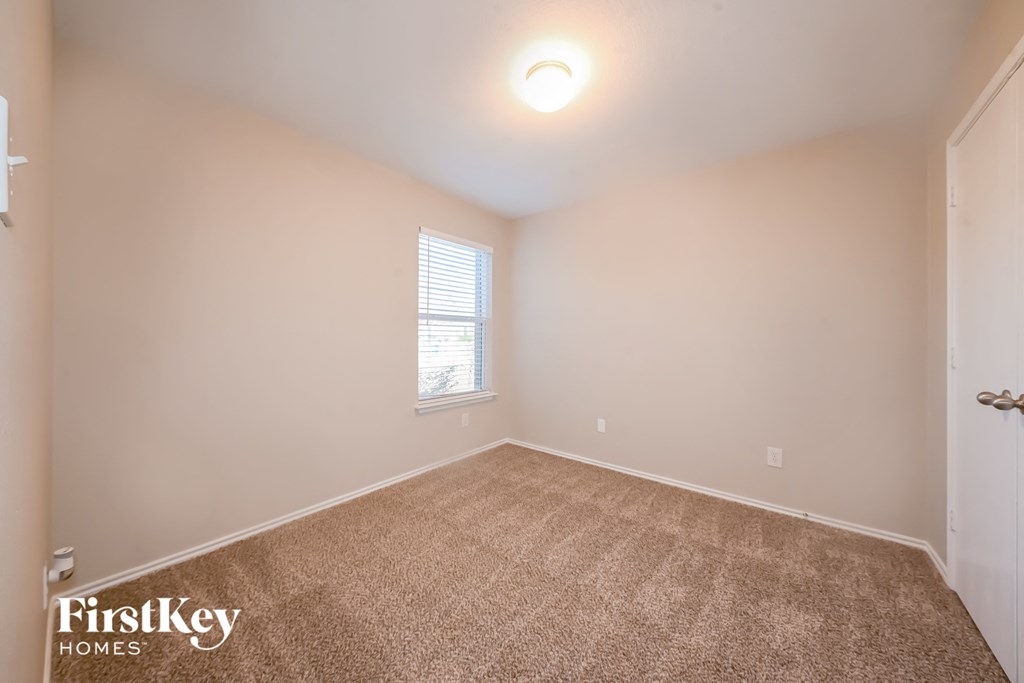 an empty room with carpet and a window