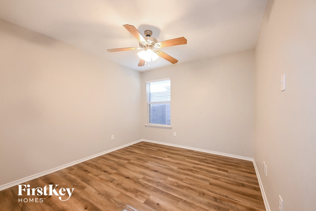 the living room has hardwood flooring and a ceiling fan