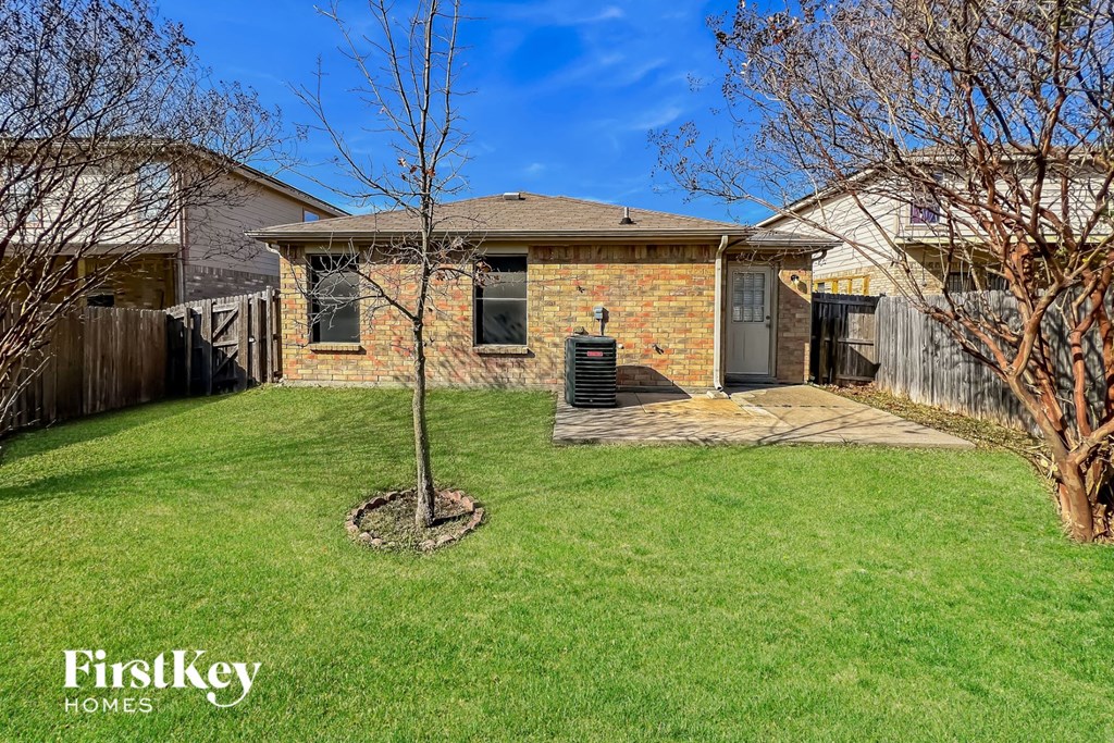 a small brick house with a yard and a tree