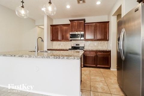 A kitchen with a white counter top and brown cabinets.