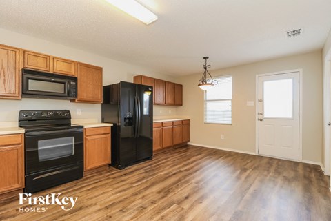 A kitchen with wooden cabinets and black appliances.