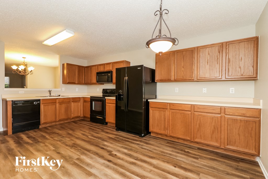 A kitchen with wooden cabinets and black appliances.