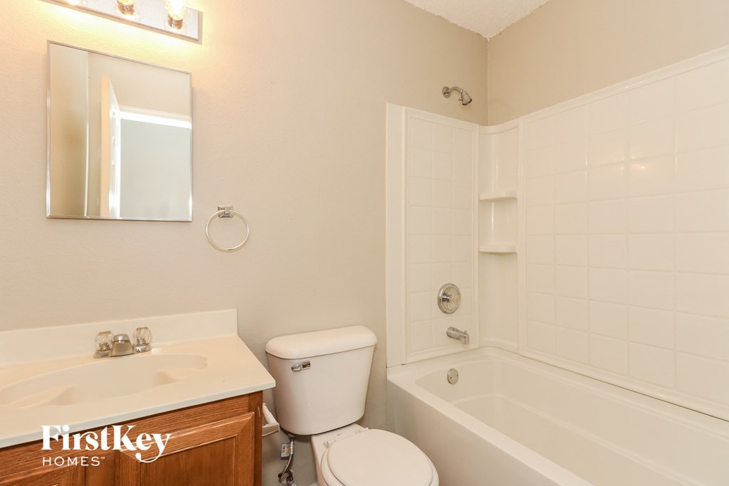 A white bathroom with a toilet, sink, and bathtub.
