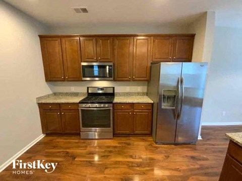 A kitchen with wooden cabinets and a stainless steel refrigerator.