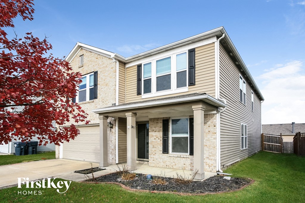 a tan and with a red tree in the yard