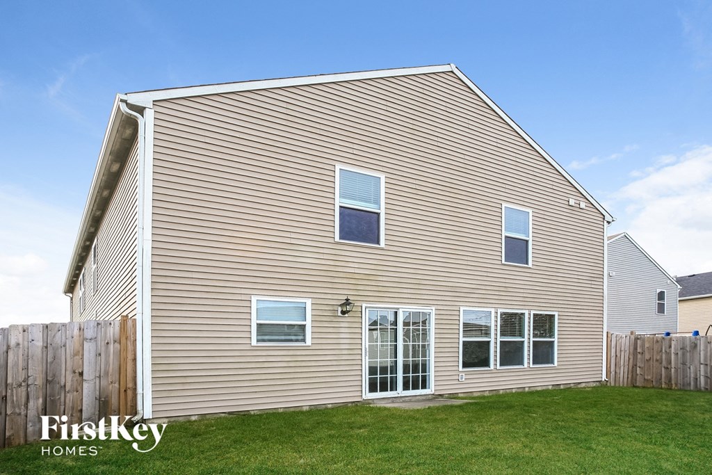 the outside of a house with brown siding and a yard