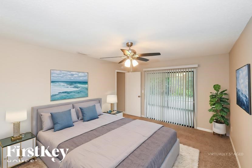 A bedroom with a large bed and a ceiling fan.