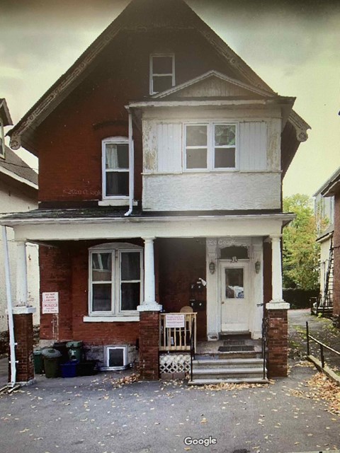 a red brick house with a porch and a white door