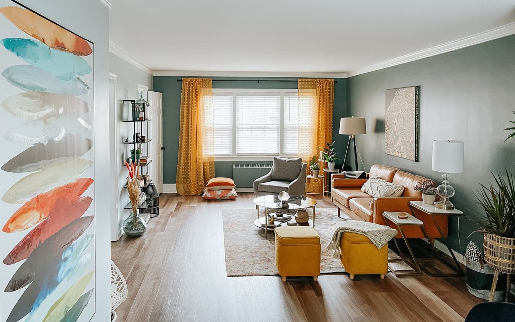 a living room filled with furniture and a painting on the wall