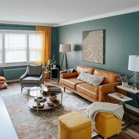 a living room with blue walls and a brown leather couch