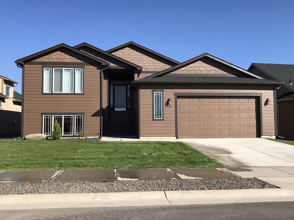 a house with a garage door and a lawn