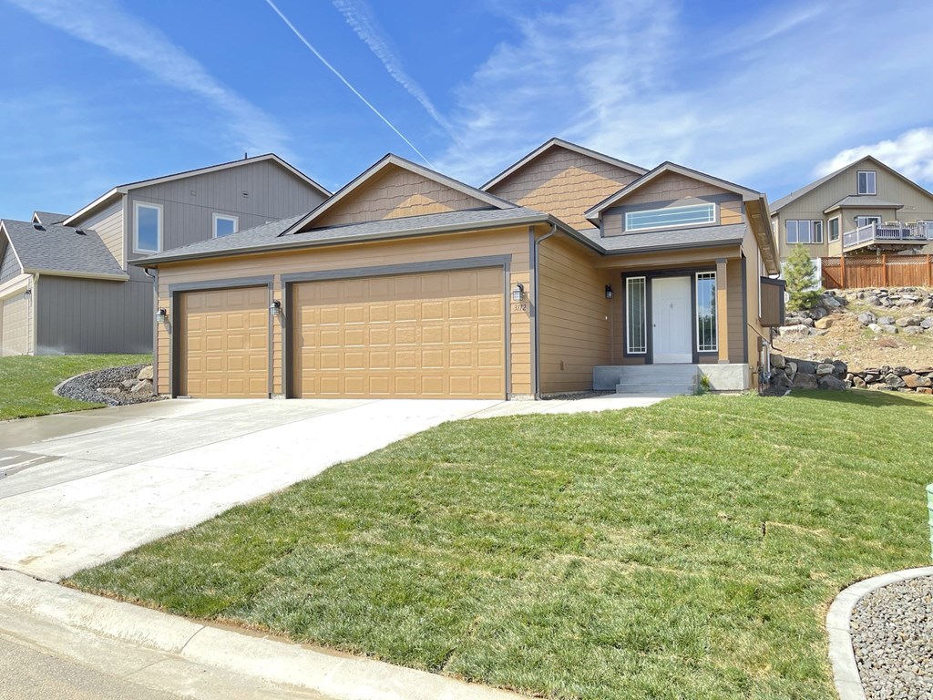 a house with a garage door in front of a lawn