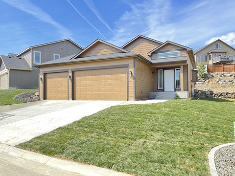 a house with a garage door in front of a lawn