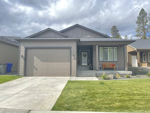 a home with a garage door and a lawn