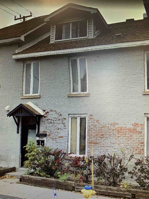 A house with a grey brick wall and a wooden door.