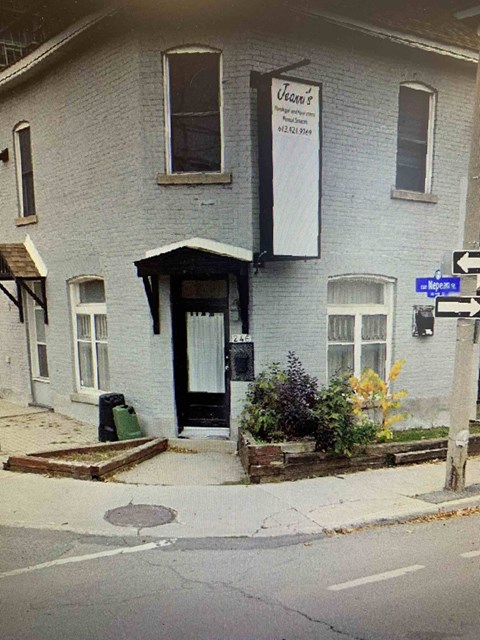 A white building with a black door and a sign that says "Vern's".