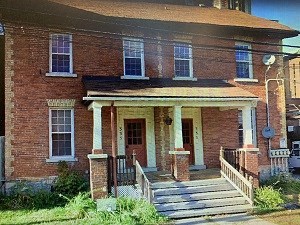 a large brick house with a porch and stairs