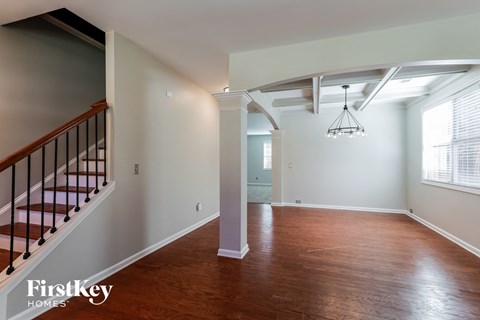 a renovated living room with a staircase and wood flooring