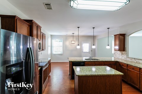 an updated kitchen with wood cabinets and granite counter tops